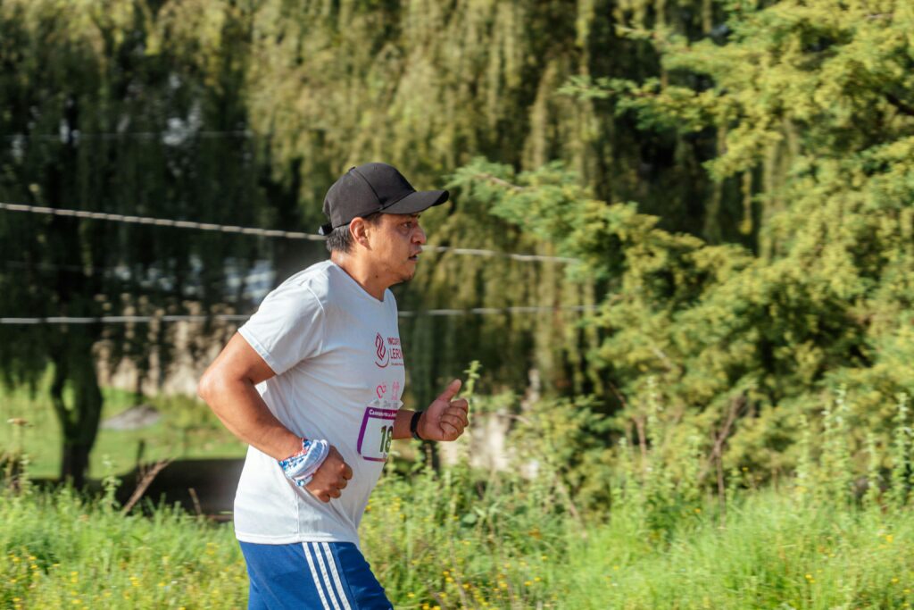 A man running through a park, showcasing fitness and exercise in nature.